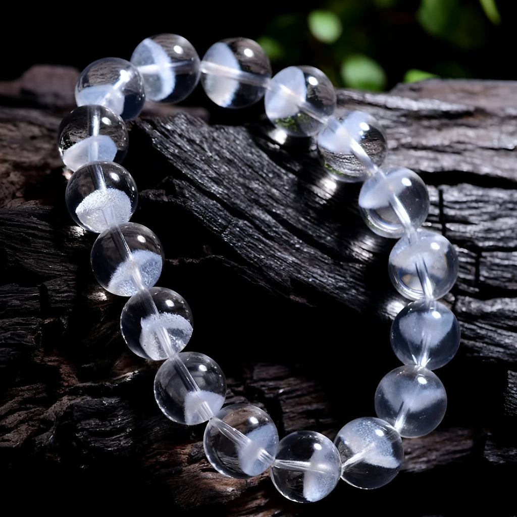 Women's white crystal bracelet with ghost pyramid beads and a ruyi charm, shown on a wrist.