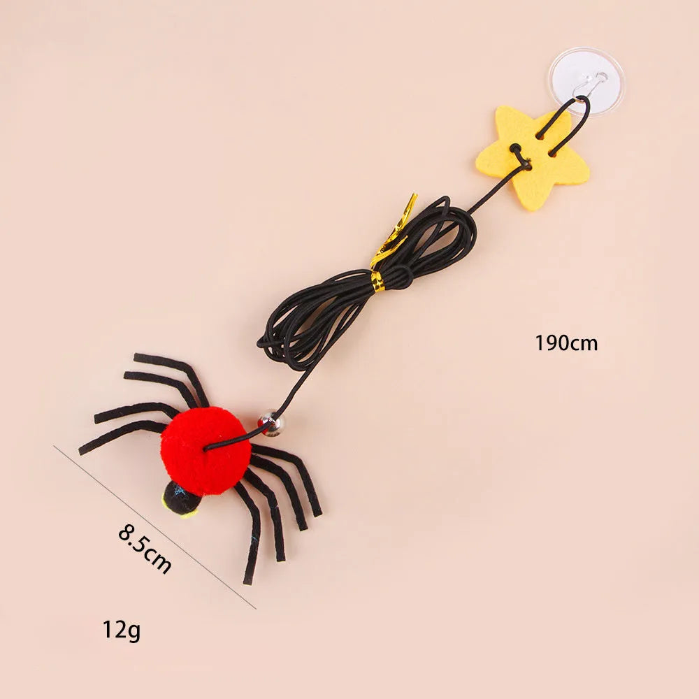 Red and yellow cat toy with feather and bell spider hanging from a door on an elastic rope.