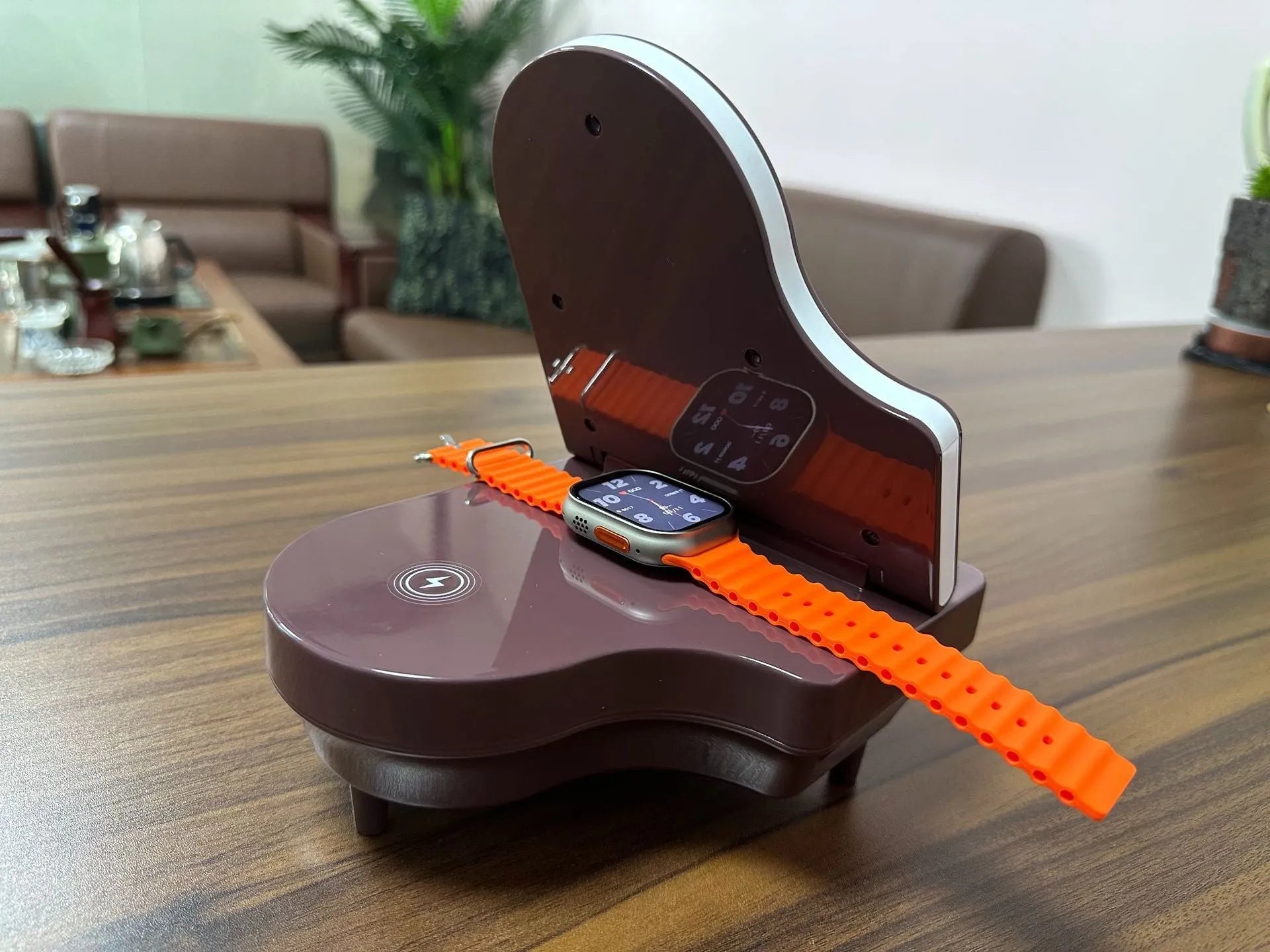Black 3-in-1 Bluetooth speaker with wireless charger and phone holder on a desk