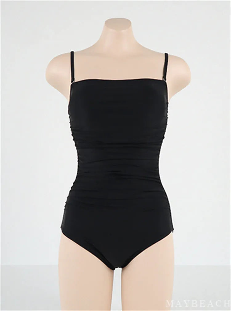 Sling top one-piece swimsuit with belly pleats in blue, shown on a model.