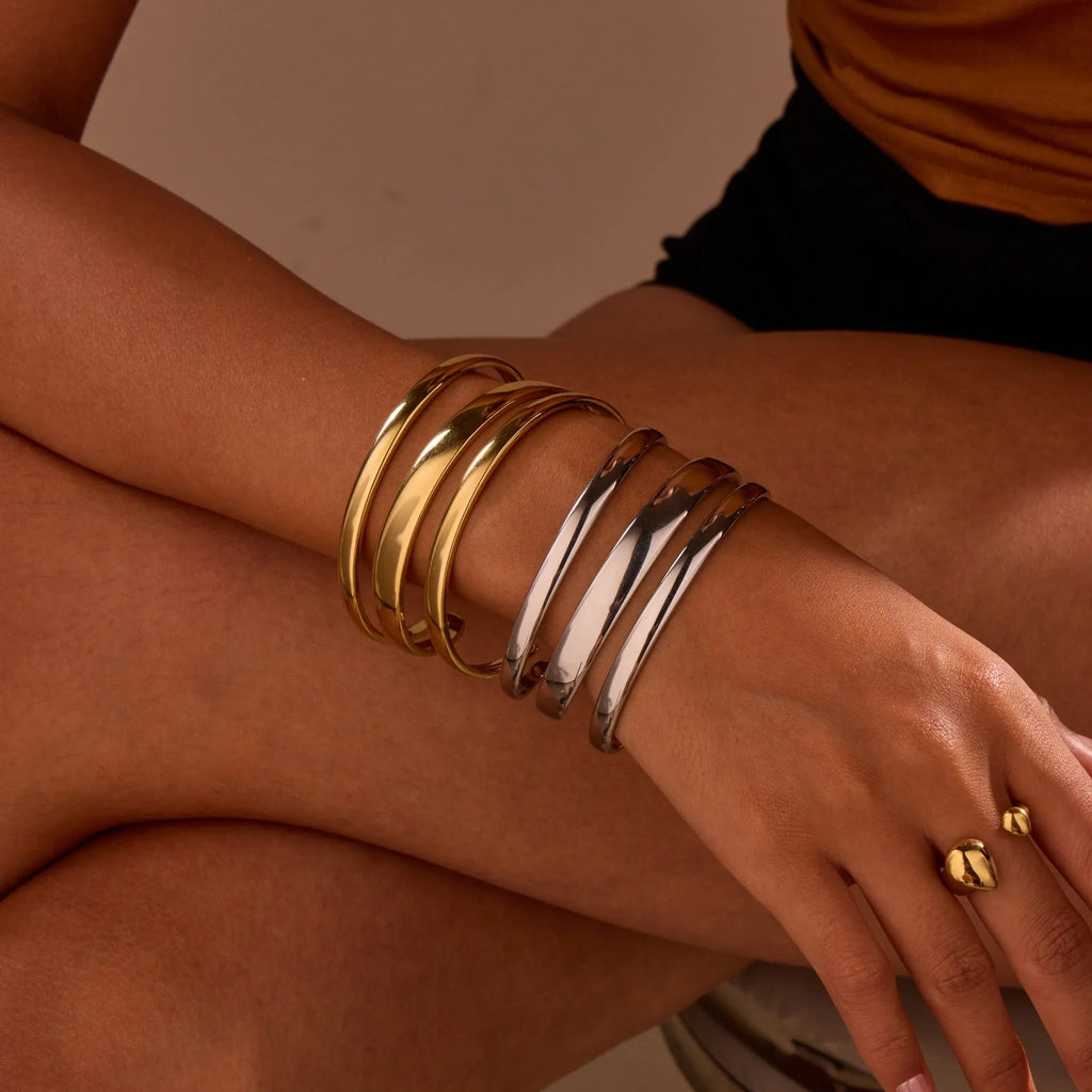 A geometric line design bracelet for women on wrist, shown in stainless steel with a simple opening clasp.
