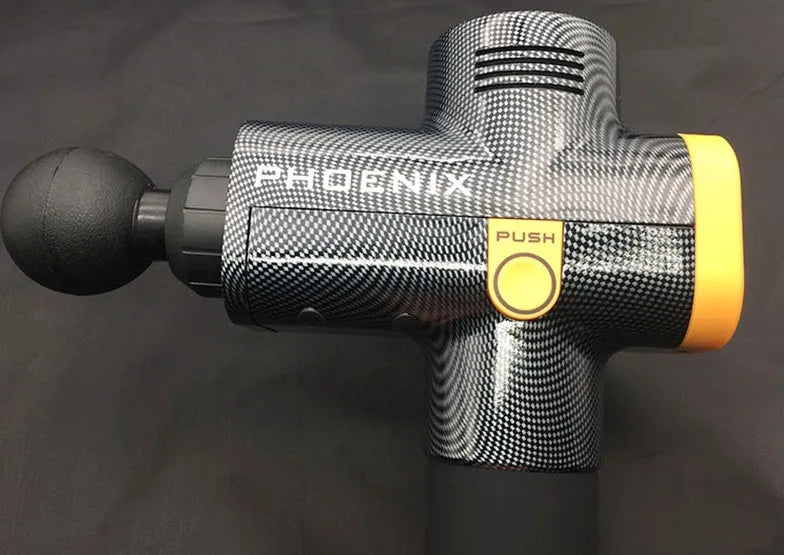 Black fascia massage gun with four different coloured massage heads on a table