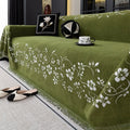 Chenille sofa cover with embroidered magnolia pattern in garland black, coffee, and green colours