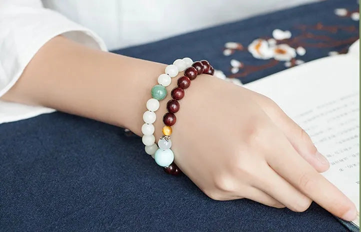 Natural white jade Bodhi bracelet with transfer beads on a neutral background