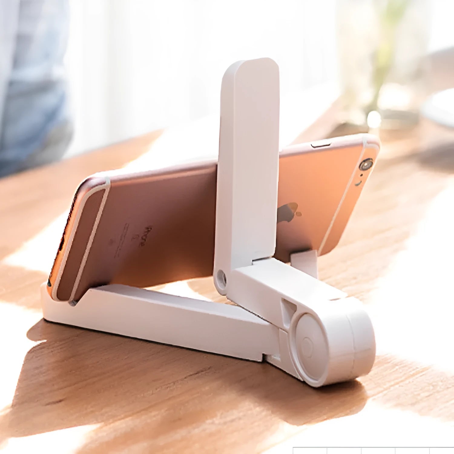 Black foldable tablet holder open on a table, holding a smartphone in landscape mode.