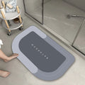 Blue oval blended bathroom floor mat on tiled floor next to a bath.