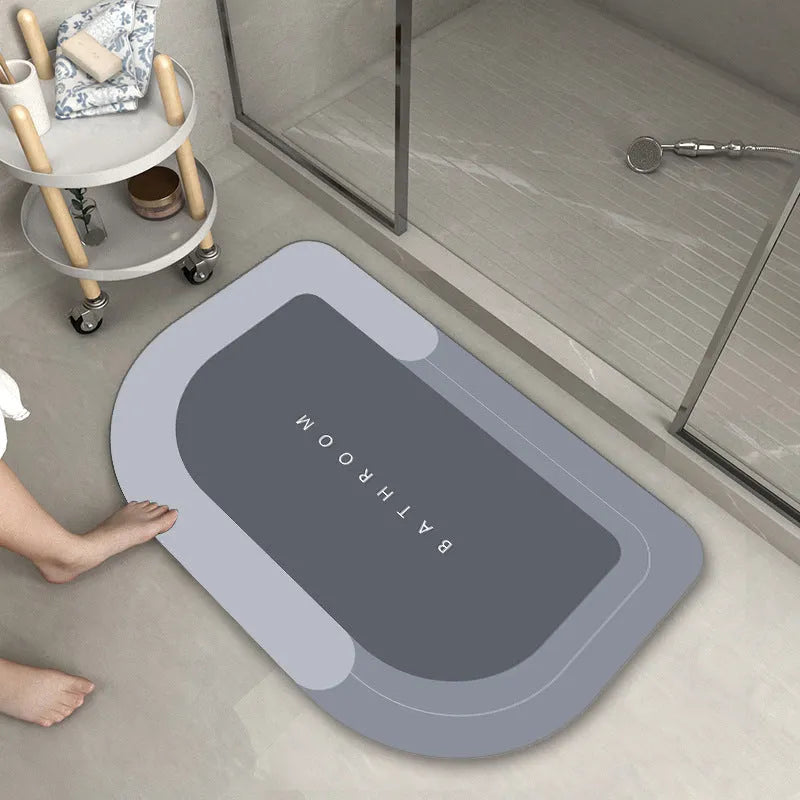 Blue oval blended bathroom floor mat on tiled floor next to a bath.