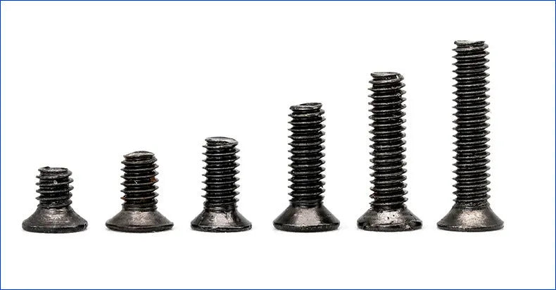 Assortment of small black countersunk head machine screws with cross-head drives for laptop repair.