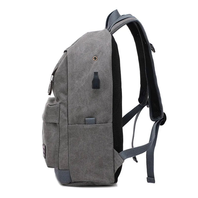Canvas USB charging backpack in grey colour showing front pockets and side USB port.
