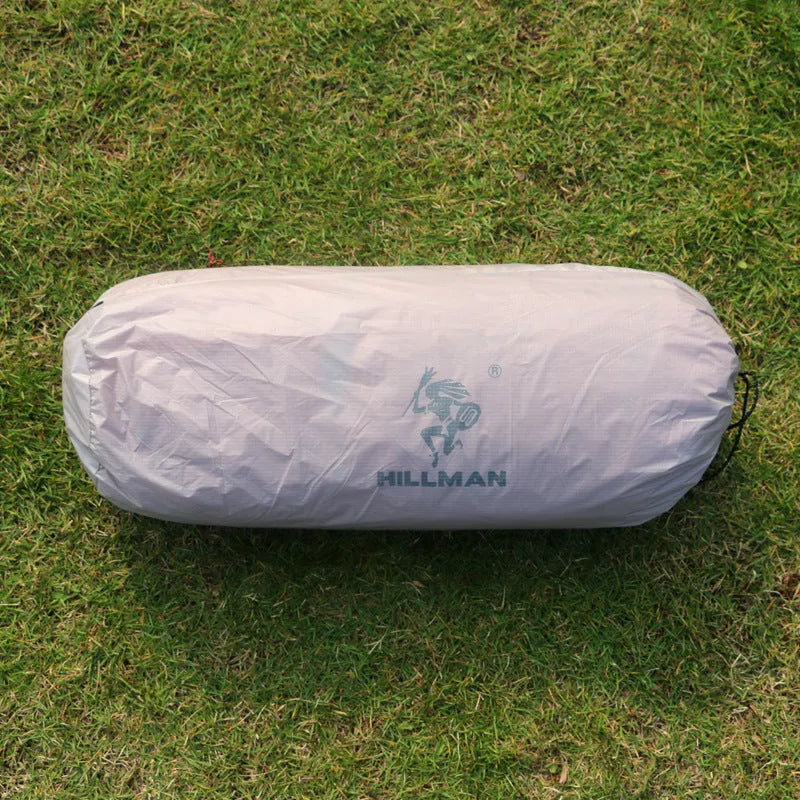 Grey outdoor multi-person tent with aluminum pole and nylon fabric set up on grass