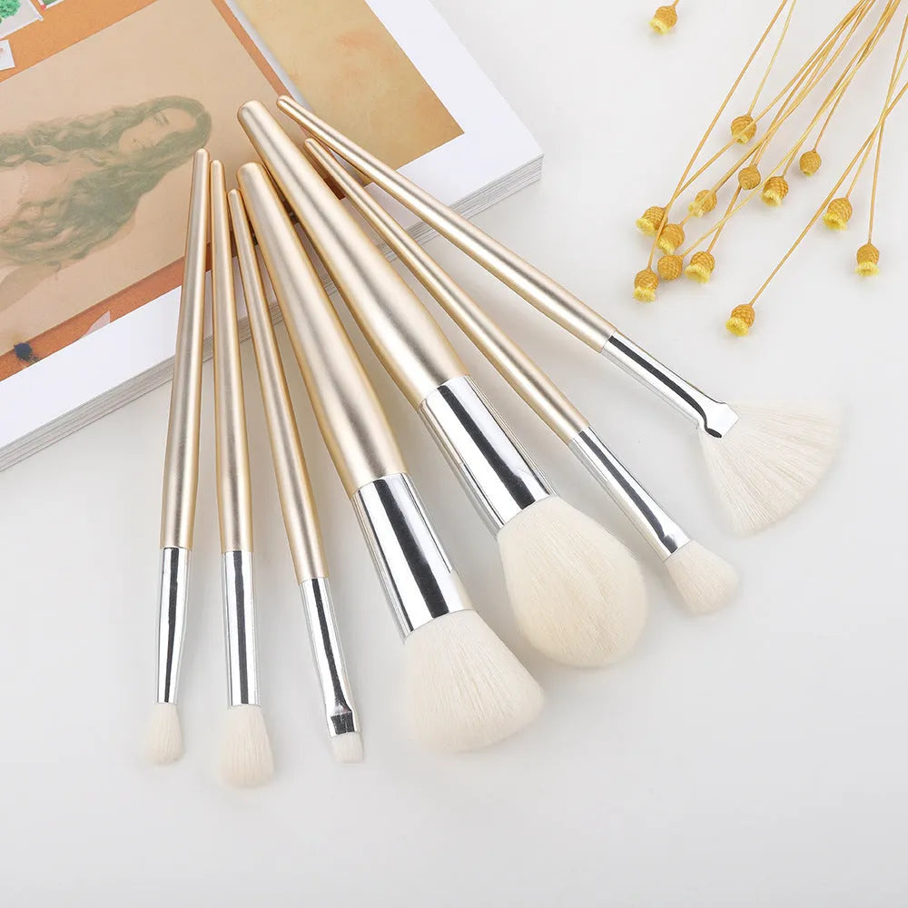 Water drop pattern makeup brush set of seven brushes with blue gold pink purple and transparent handles on white background