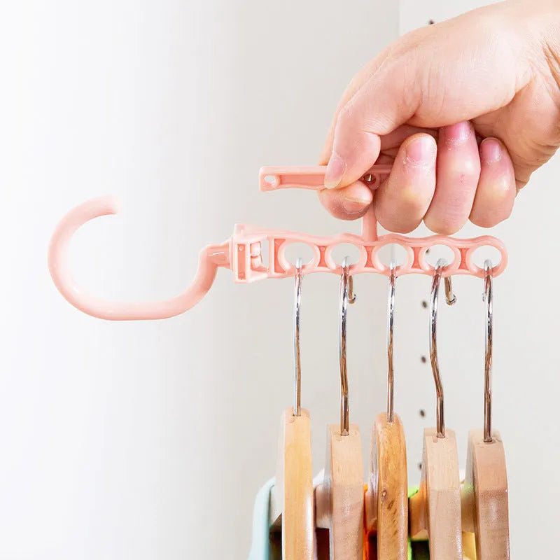 Blue revolving plastic wardrobe hanger with five holes and a top handle on a white background.