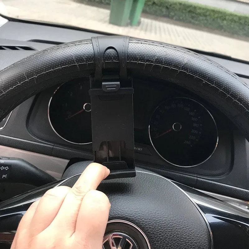 Black steering wheel phone holder clip mounted on car steering wheel holding smartphone