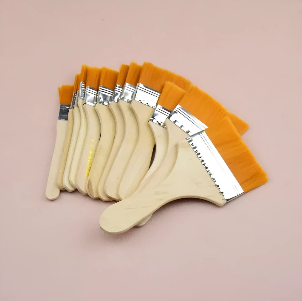 Twelve nylon board brushes with wooden handles in sizes 1 to 12 laid out on a surface