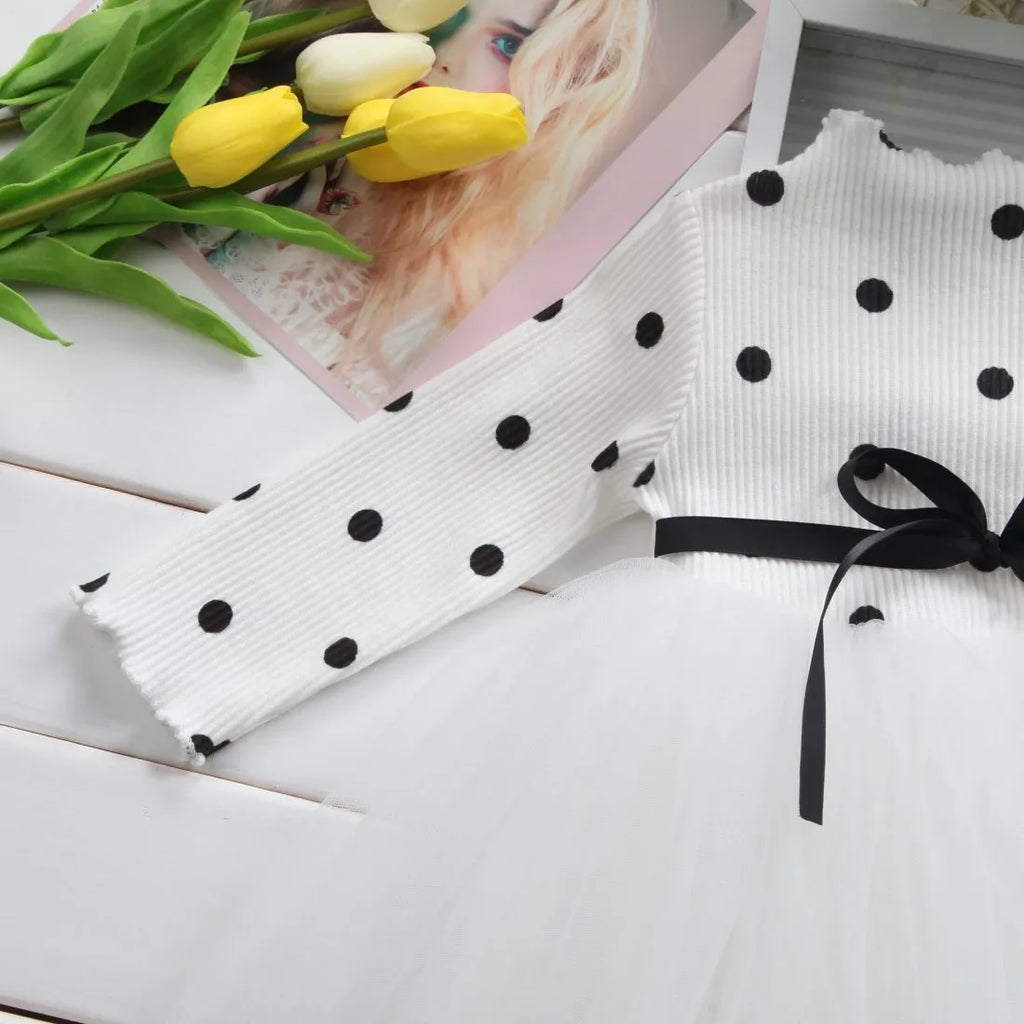 Baby girl in a long sleeve black lace tutu dress, suitable for christenings and parties.