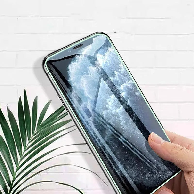 Luminous full cover tempered glass screen protector for iPhone glowing softly in dark conditions.