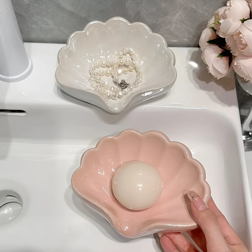 White and pink plastic shell-shaped soap dish for bathroom counter.