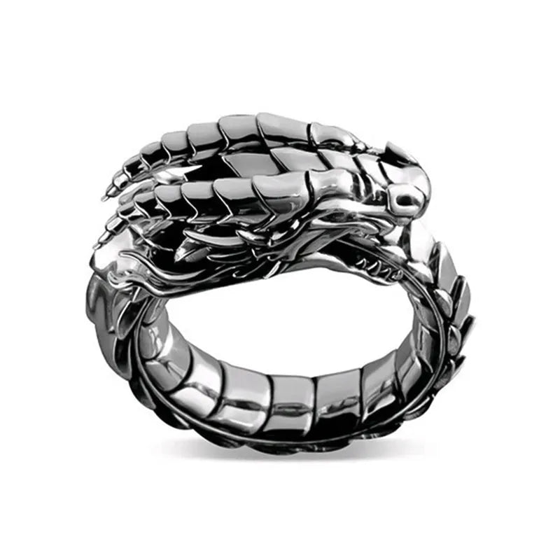 Vintage dragon male ring in ancient silver metal on a plain background.