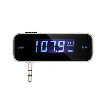 Black car FM transmitter with LCD display showing FM frequency, 3.5mm aux plug connected to smartphone
