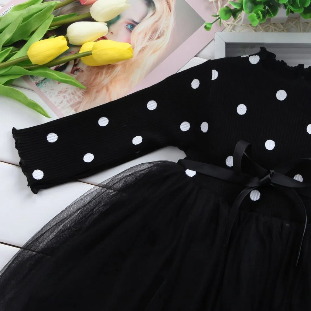 Baby girl in a long sleeve black lace tutu dress, suitable for christenings and parties.
