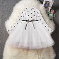 Baby girl in a long sleeve black lace tutu dress, suitable for christenings and parties.