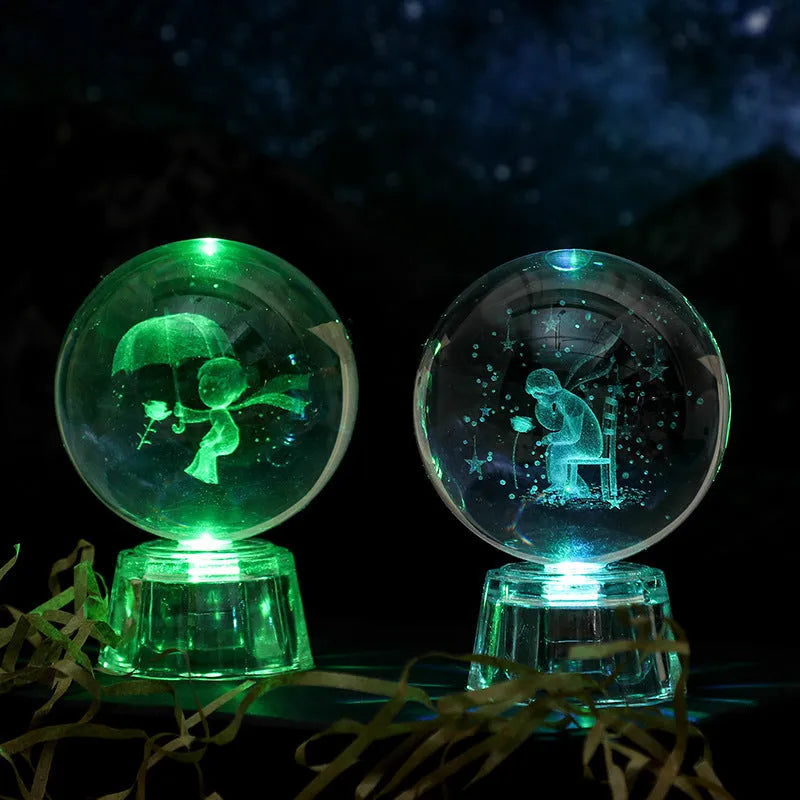 6cm transparent crystal ball ornament with illuminated inner carving of celestial designs on a table