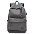 Canvas USB charging backpack in grey colour showing front pockets and side USB port.