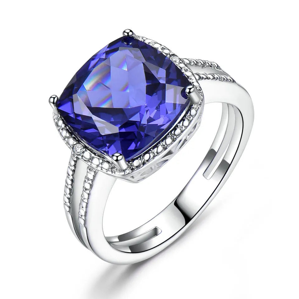 Women's sterling silver ring with a blue tanzanite gemstone on a model's hand.