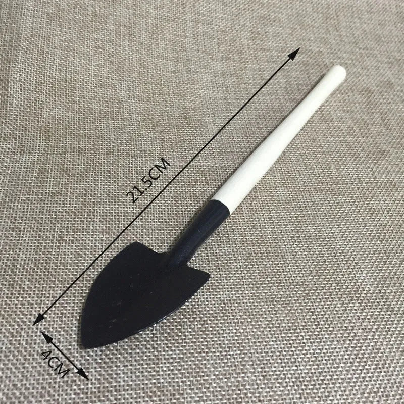 Succulent gardening tool set with plastic watering can, mini shovel, rake, tweezers, and a small bucket on a table