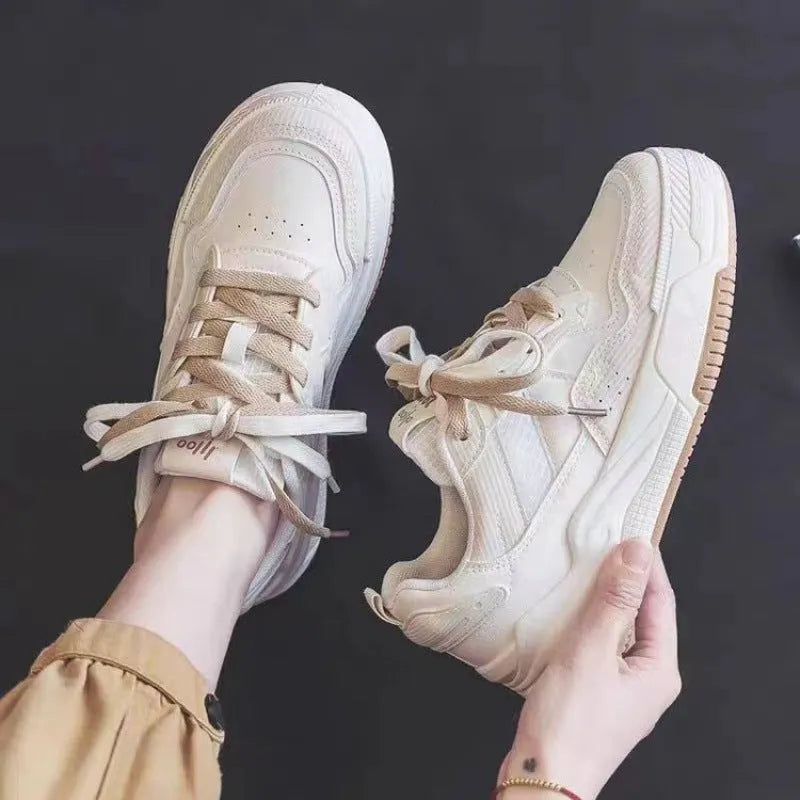 Pink and white low-top sneaker with a height-increasing rubber sole.