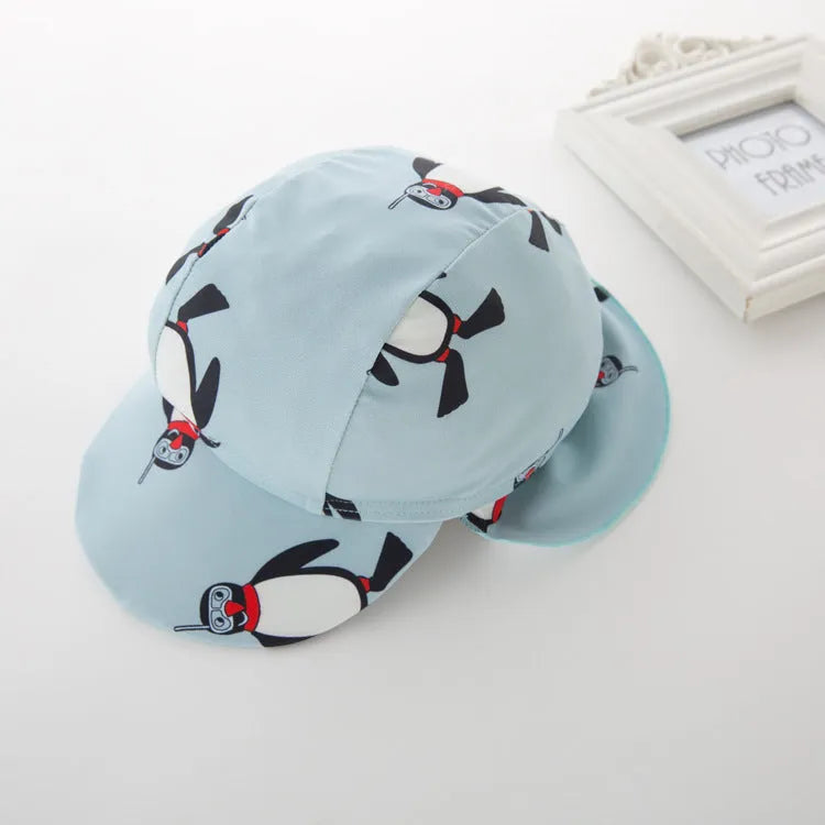 Boys' long sleeve penguin print swimsuit and matching swim cap set on a white background.