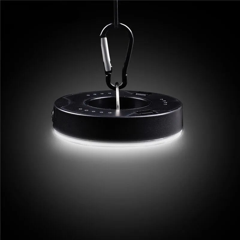 Primary colour COB LED tent light with carabiner hook and transparent lampshade on a dark background