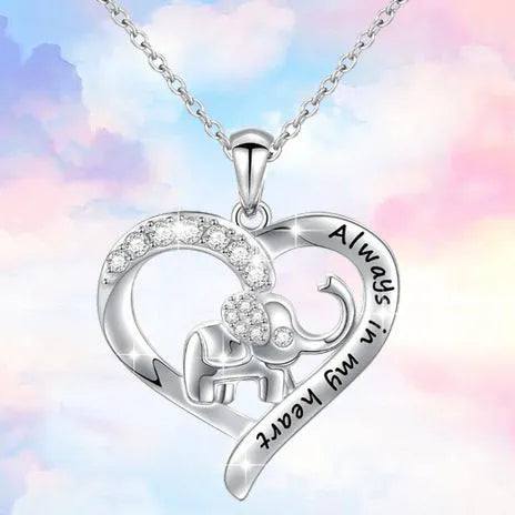 Silver alloy elephant pendant necklace with personalised letter charm on a flat surface