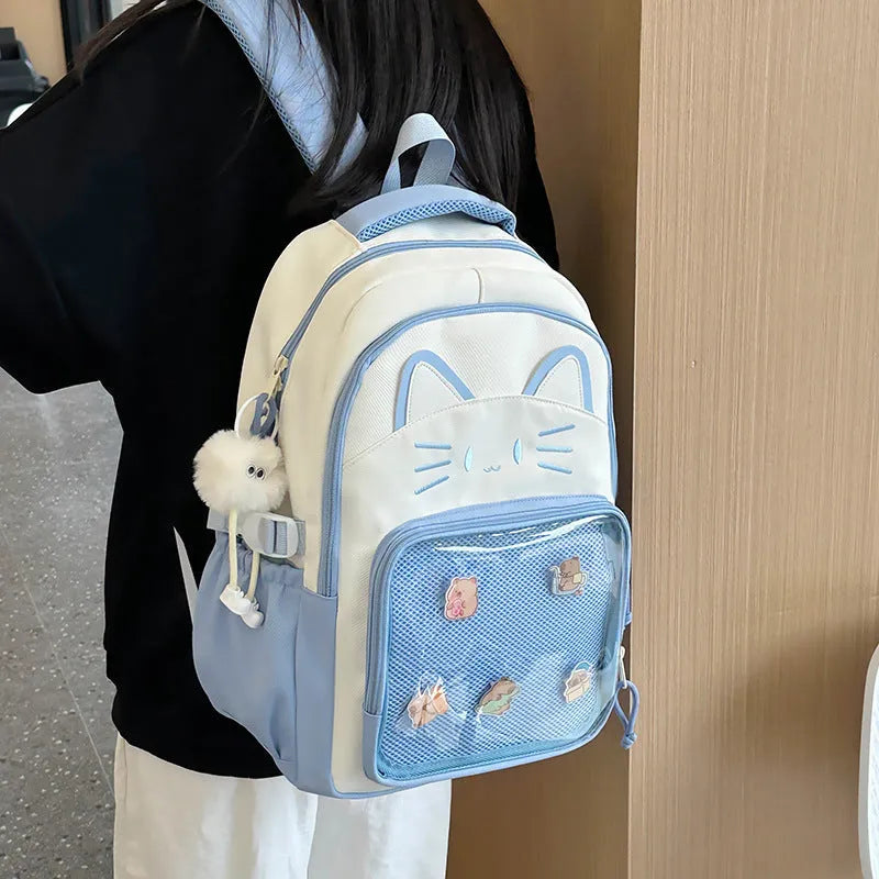 Cartoon style large capacity nylon backpack in pink with badge pendant, showing curved shoulder straps