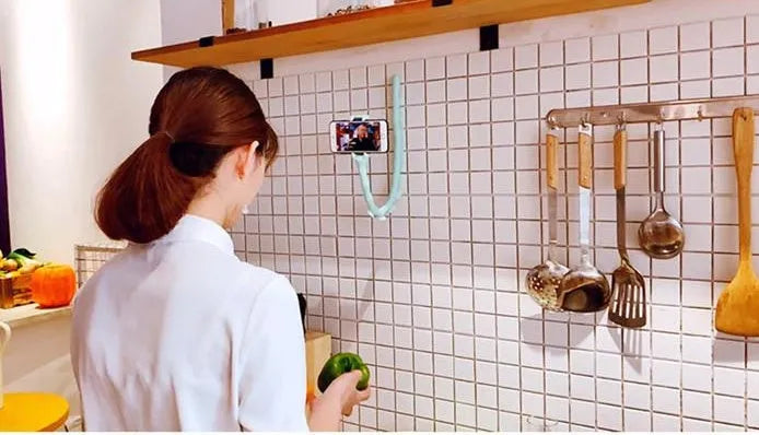 Flexible rubber phone holder with suction cup mounted on a surface showing 360-degree rotation capability