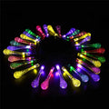 String of solar-powered bubble drop LED lights with a solar panel and ground spike for outdoor garden use.