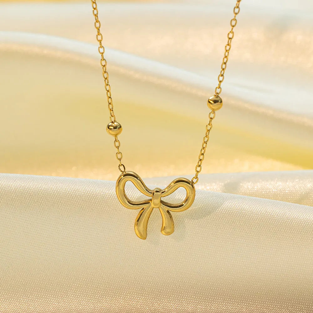 Gold electroplated bow necklace on cross chain with adjustable 41-50cm length