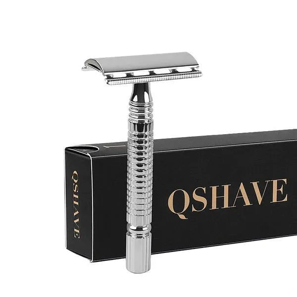 Double edged safety razor with metal handle and head next to its blade and storage box.