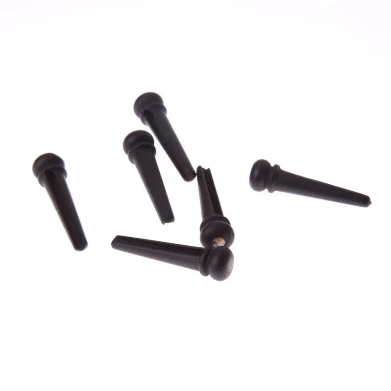 Six ebony folk guitar string nails with matt black finish and 5.3mm bayonet diameter