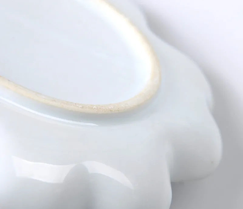 White handmade ceramic plum blossom shaped artist palette for painting.