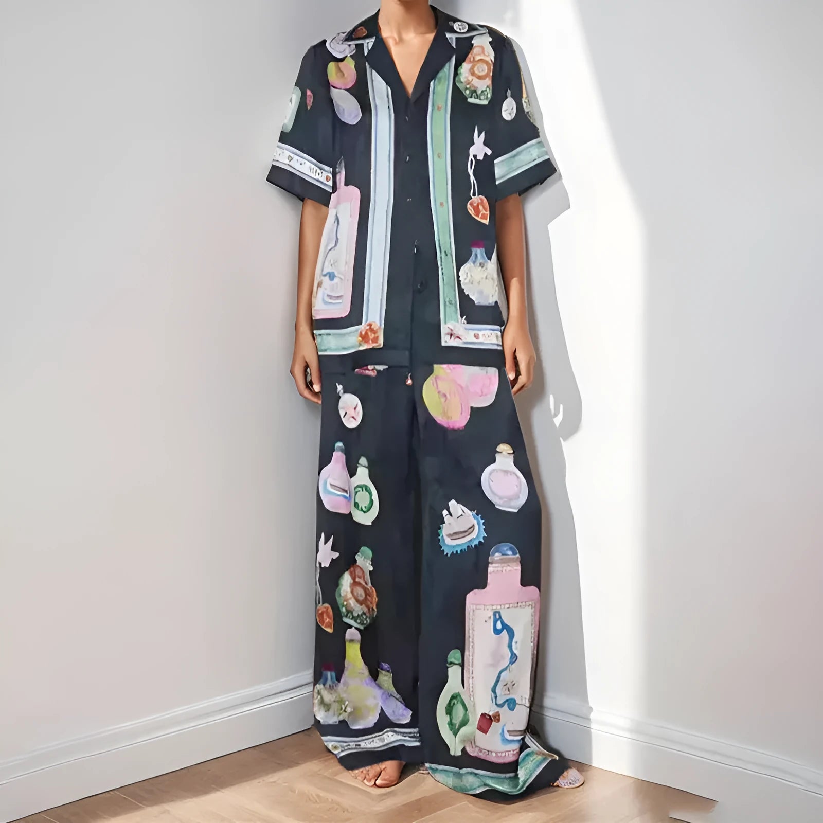 Black women's casual set with cartoon pattern, featuring a short sleeve cardigan and matching trousers.