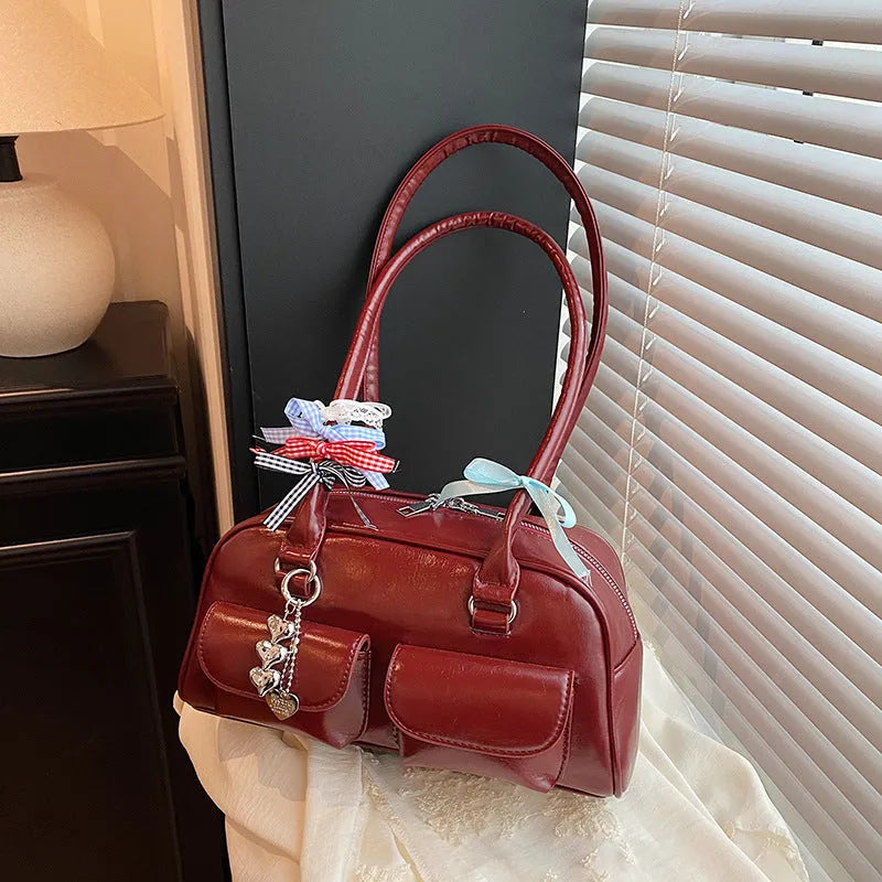 Retro pillow-shaped PU leather women's handbag with double shoulder strap in black colour with ribbon pendant