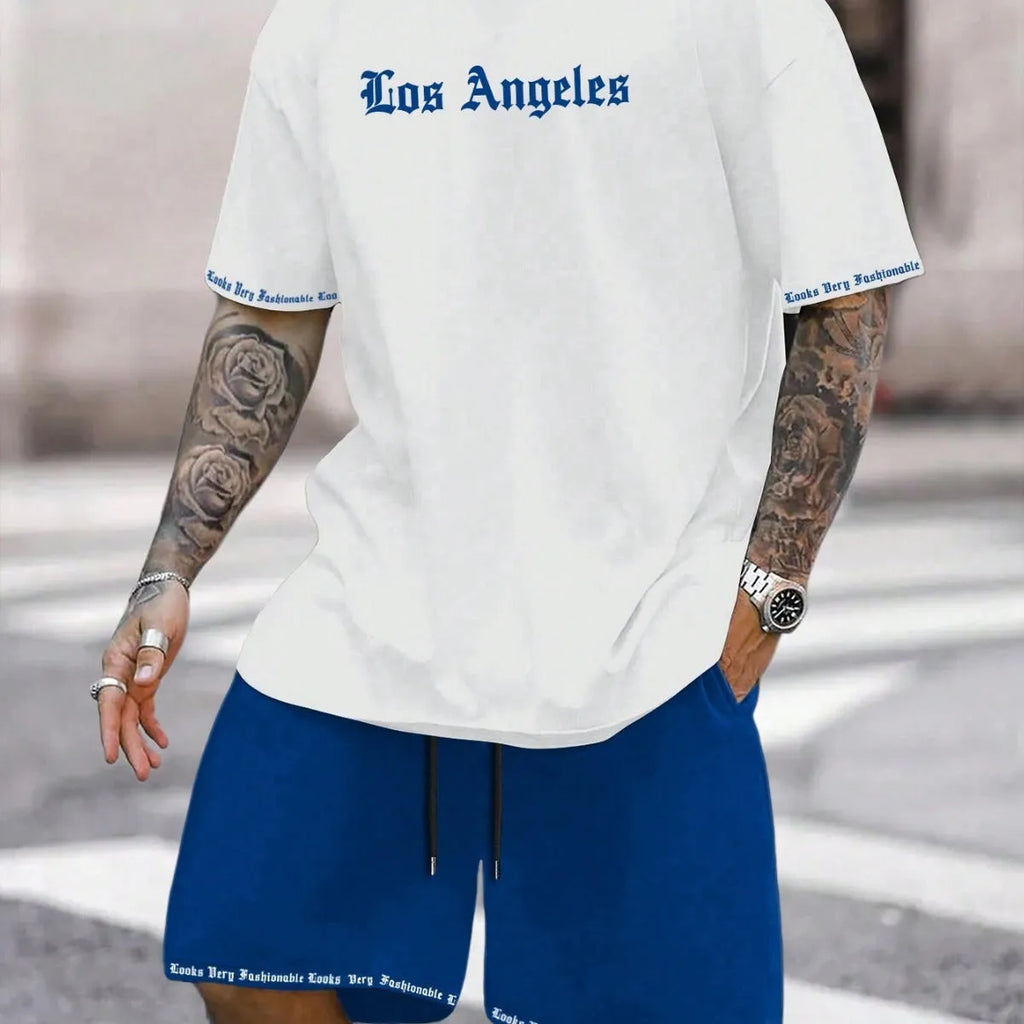Man wearing a blue printed short-sleeve top and matching shorts from a two-piece sports casual set.