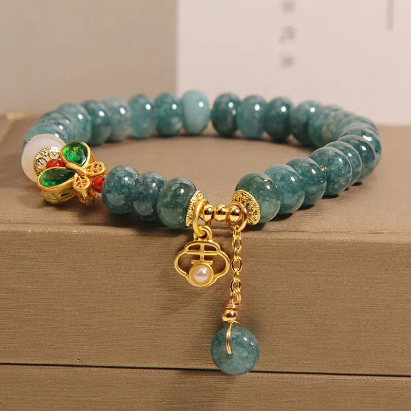 Women's blue water jade abacus bead bracelet with alloy charms, white agate, and rhinestone details