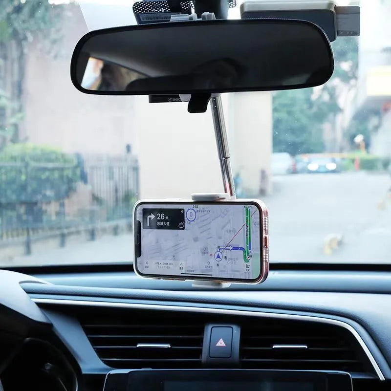 Black ABS plastic mobile phone bracket mounted on car rearview mirror holding smartphone