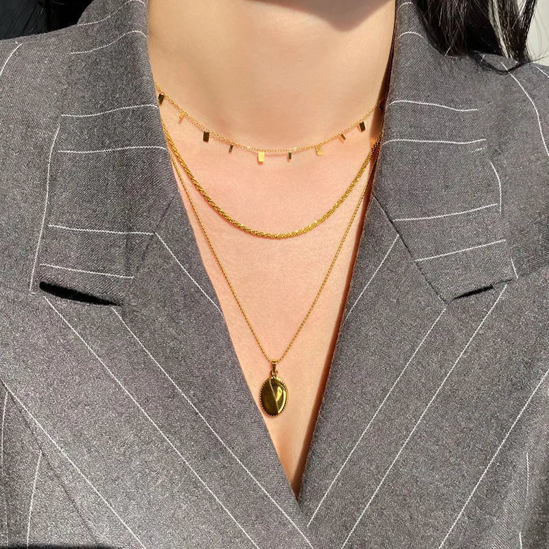 Gold titanium steel necklace with round circle, waterdrop and rectangle charms on a cross chain, adjustable 21-50cm.