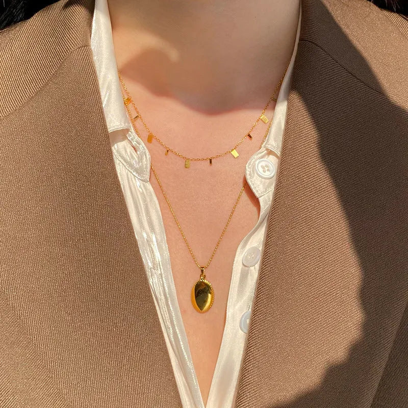 Gold titanium steel necklace with round circle, waterdrop and rectangle charms on a cross chain, adjustable 21-50cm.