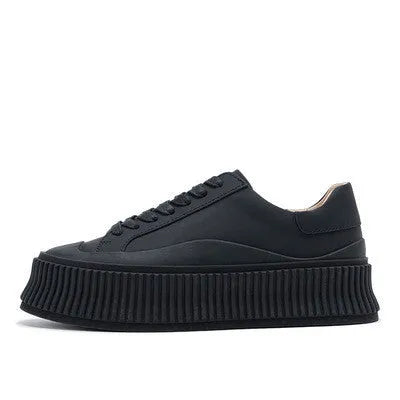 Women's white chunky platform trainers with a thick rubber sole, suede upper, and cross-binding detail.