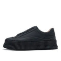 Women's white chunky platform trainers with a thick rubber sole, suede upper, and cross-binding detail.