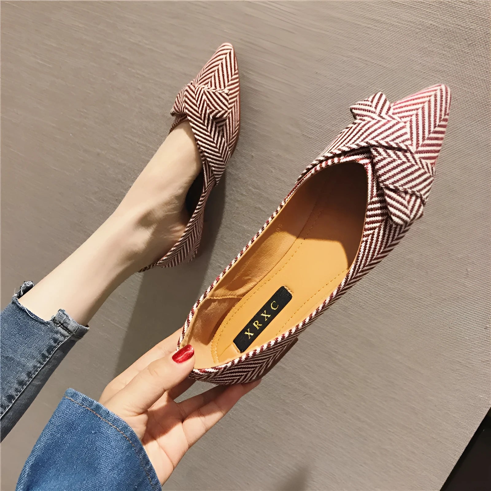 Women's red pointed toe shallow mouth flats with a low flat heel on a white background.